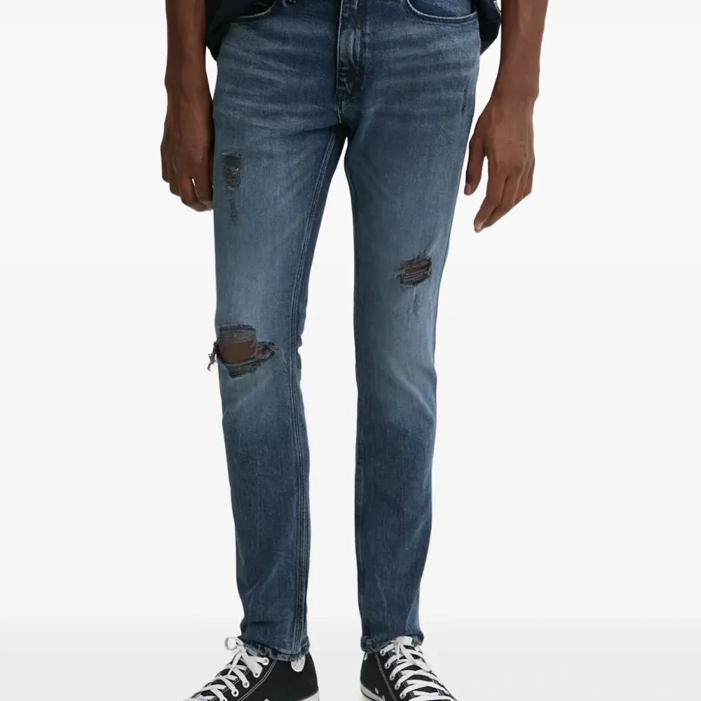 Джинсы с эффектом потертости и карманами