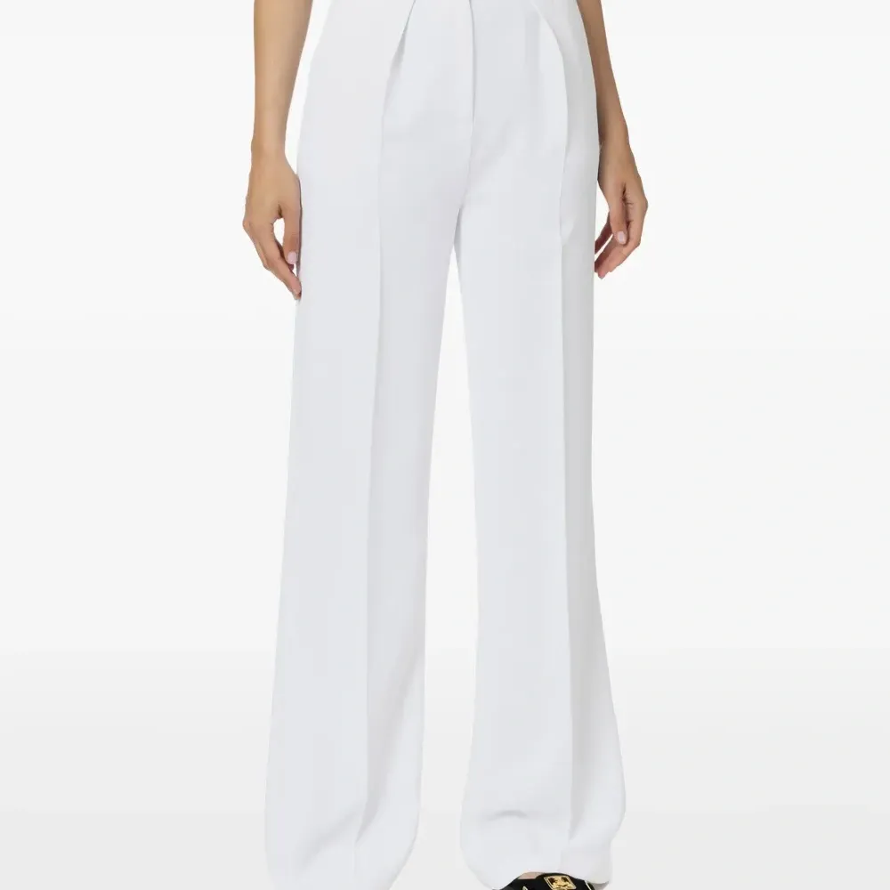 брюки со складками и золотистыми пуговицами