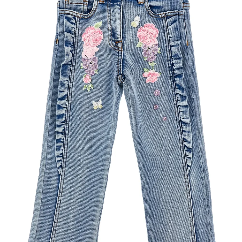 Джинсы с оборками и цветочной вышивкой