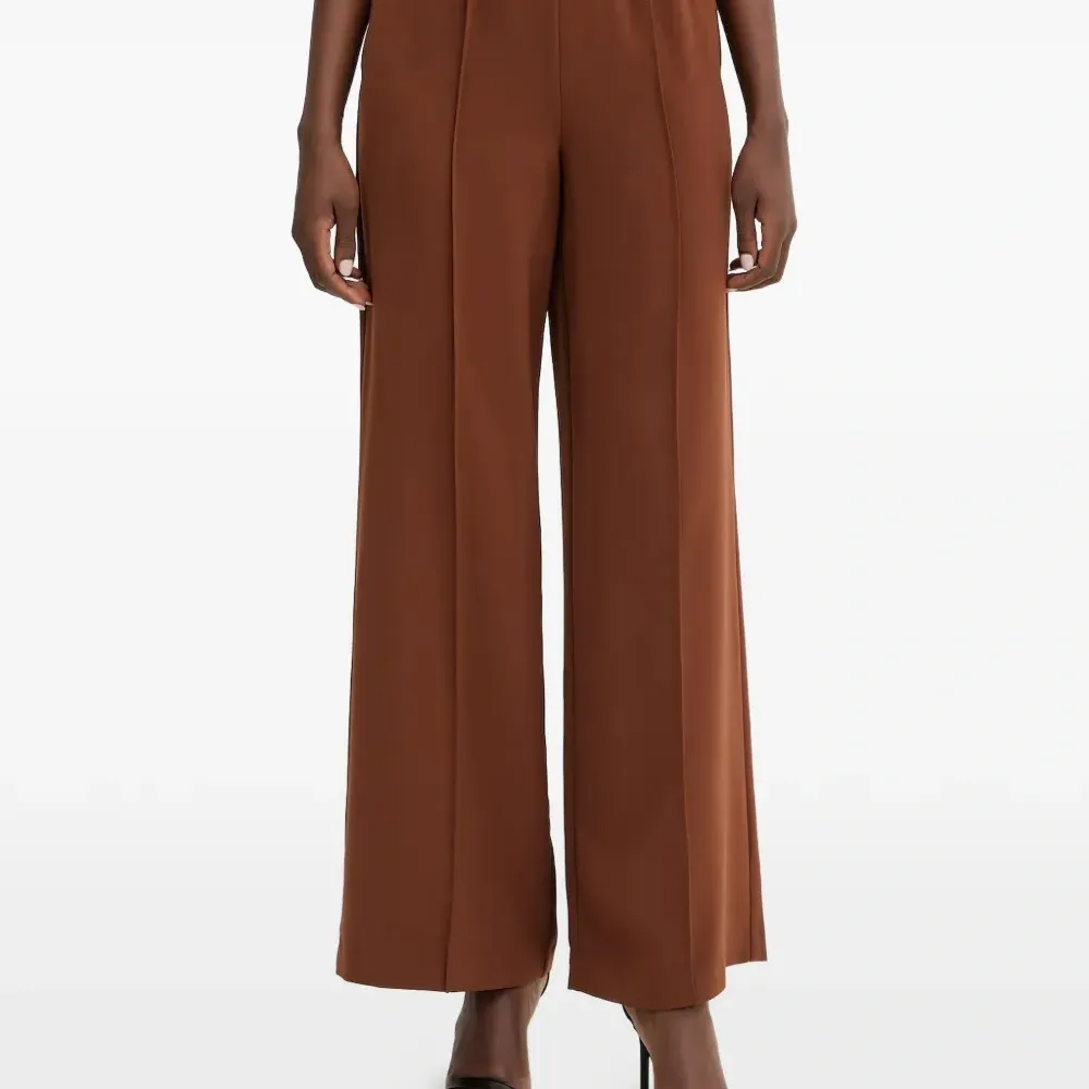 Расклешенные брюки с отделкой в виде швов